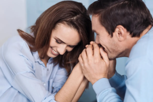 A couple is sharing a tender, joyful moment with heads close together, smiling.