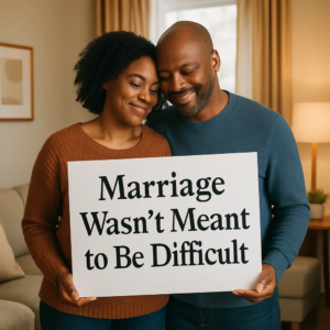 A smiling couple is holding a sign that reads, "Marriage Wasn't Meant to Be Difficult", answering the question of "Why is Marriage Difficult?"